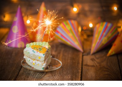 Cake With Sparkler On Table On Wooden Background