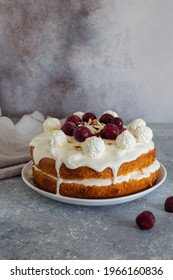 Cake with whipped cream and cherries on gray stone background close up