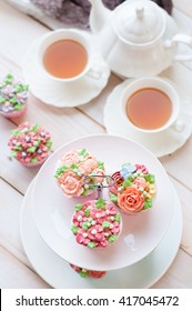 Cakes And Macaroons On Two Tiered Tray With Teapot And Cup Background. Afternoon Tea