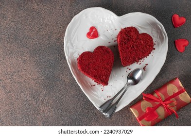 Cakes Red velvet in the shape of hearts on white plate, roses and wine for Valentines Day on brown background, Copy space, Top view