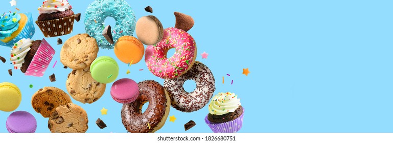 Cakes, sweets, confectionery collage background. Donuts, cookies cupcakes macaroons flying over blue background - Shutterstock ID 1826680751