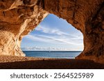 Cala Luna. Sardinia. Beautiful Mediterranean sea and blue sky view from the cave. White sailboat in the center. Italy.