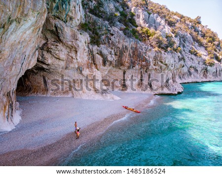 Cala Luna Sardinia, young couple with kayak boat on the beach of Cala Luna Sardinia Italy
