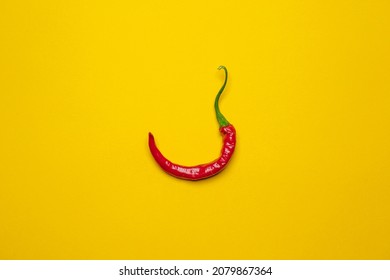 Calabrian red hot chilli pepper on a yellow background. Cool minimal flat lay, copy space