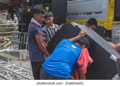 Calape, Bohol, Philippines - May 2022: Men Unload Large Speakers In Preparation For A Large Dance Party Event At The Town Plaza During Fiesta Season.