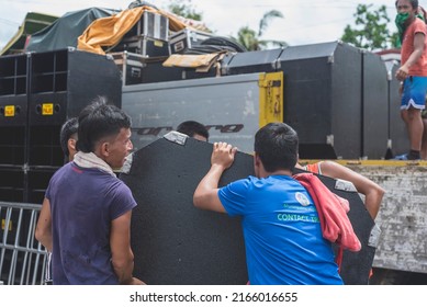 Calape, Bohol, Philippines - May 2022: Men Unload Large Speakers In Preparation For A Large Dance Party Event At The Town Plaza During Fiesta Season.