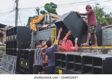 Calape, Bohol, Philippines - May 2022: Men Unload Large Speakers In Preparation For A Large Dance Party Event At The Town Plaza During Fiesta Season.