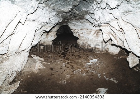 Calcareous cave, clay with water on the floor of the cave passage, karst hole, dark corridor underground, speleology. High quality photo