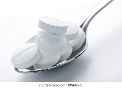 Calcium Supplement Pills Piled On Metal Spoon Closeup