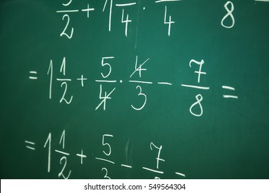 Calcualting with fractions on green blackboard at primary school - Shutterstock ID 549564304