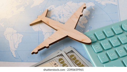 Calculation of the cost of rest or emigration, air flight. Travel background. Traveler, tourist accessories, toy airplane, calculator on map background. Top view. - Shutterstock ID 2390659961