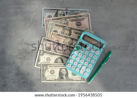 Calculator and banknotes, dollars on a gray table. Top view. Business investment during coronavirus period. Shadow business, bribery.