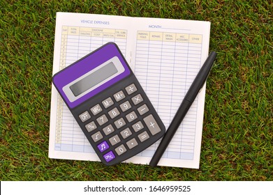 Calculator And Black Felt Tip Pen And Expense Report Book Green Turf Grass