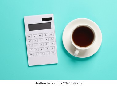 Calculator and coffee cup on a blue background. Top view - Shutterstock ID 2364788903