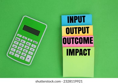 calculator and colored paper with the words input, output, outcome and impact. this results chain, inputs are used in order to carry out activities.