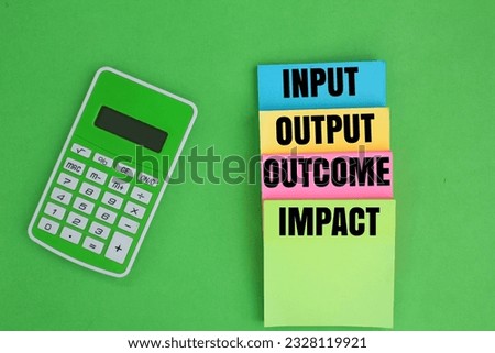 calculator and colored paper with the words input, output, outcome and impact. this results chain, inputs are used in order to carry out activities.