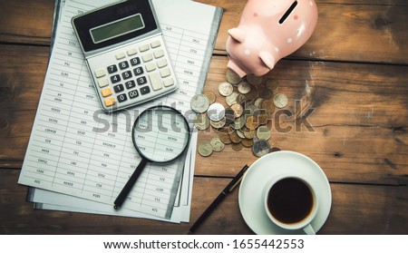 calculator and document with piggy bank on table