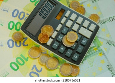 Calculator And Euro Coins On Banknotes Background.Taxes In EU Countries.Euro Currency.Budget Allocation.Recalculation Of Money. Expenses And Incomes In European Countries.