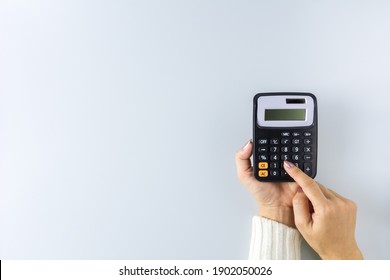a calculator in a hand on white background. - Saving money for finance accounting concept. - Shutterstock ID 1902050026