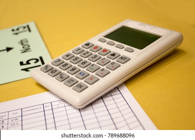 Calculator and information sheets for the bridge game on the table with yellow tablecloth