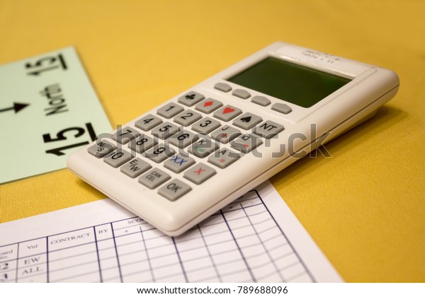 Calculator and information sheets for the
bridge game on the table with yellow
tablecloth