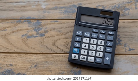 Calculator with the number 2025 on the display. Concept of finance, taxes, savings and economic crisis.