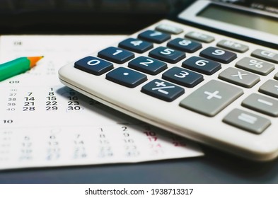 Calculator on calendar background. Calculations, finance, business.
