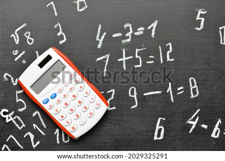 Calculator on chalkboard, top view