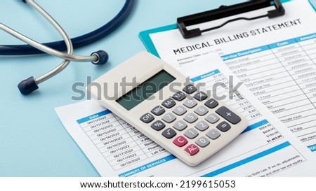 Calculator on hospital bills on blue background, medical bill and payment concept