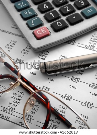 calculator, pen and glasses on financial statement