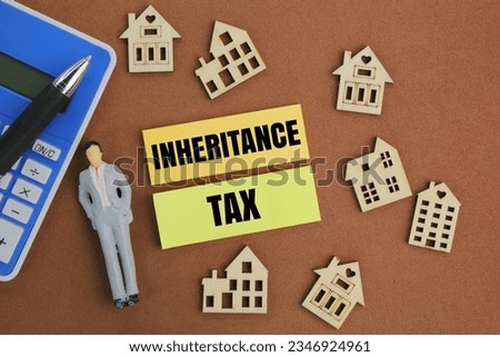 calculator, pen, house shape and colored paper with the word Inheritance Tax. concept of inheritance tax