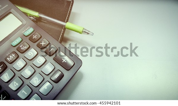 Calculator and pen on a\
book vintage style