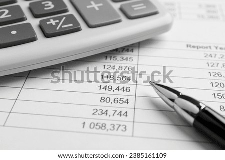 Calculator and pen on documents, closeup view