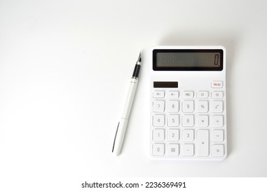 Calculator and Pen on Isolated White Background - Shutterstock ID 2236369491