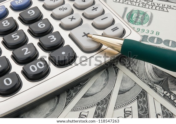 calculator and pen on us\
paper currency