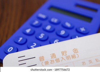 A Calculator And A Savings Account Passbook. Translation: Savings Cum Borrowing Statement. Payment.