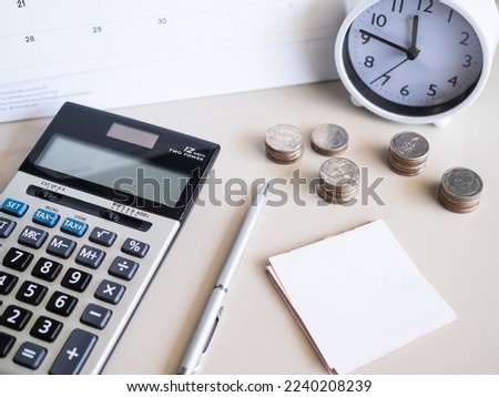 Calculator with Stack Coin,Pen,Clock,Paper Note on Table Background,Cash Money in Ofice,for Business Investment Income Finance Insurance Rate Number Bank,Accounting Currency Loan Credit Tax Concept. 