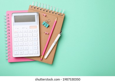 Calculator and stationery on light blue background, top view. Space for text - Shutterstock ID 1987530350