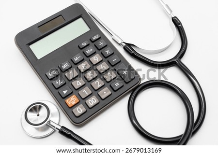 Calculator and stethoscope on white background health medicine theme with copy space. Health care costs or medical insurance.