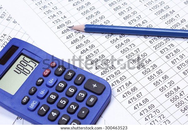 Calculator,\
tables with numbers and a pencil. Accounting documents on the\
table. Read, keep accounts. Start up, business, entrepreneurship.\
Blue calculator and pencil. Balance\
sheet.