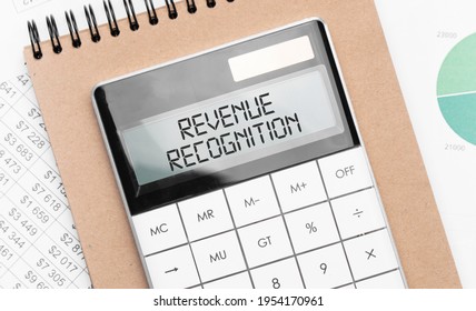 Calculator With Text Revenue Recognition With Craft Colored Notepad Pen And Financial Documents.