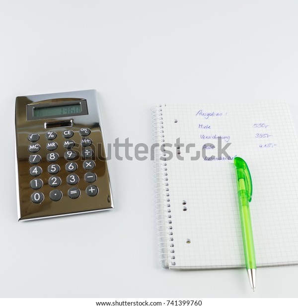 calculator and\
writing pad with a calculation of expenses, in English for\
expenses, rent, insurance, car, food,\
etc.
