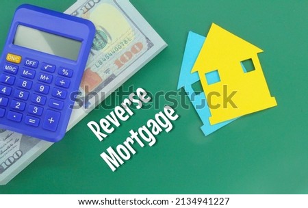 calculators, banknotes and paper houses with the word reverse mortgage
