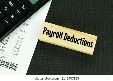 calculators, receipts and wooden boards with the word payroll deductions - Shutterstock ID 2142407163