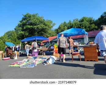 Caledonia, NS, CAN, August 6, 2022 - Tables Set Up At A Multi Family Yard Sale With Objects On Them And People Browsing.