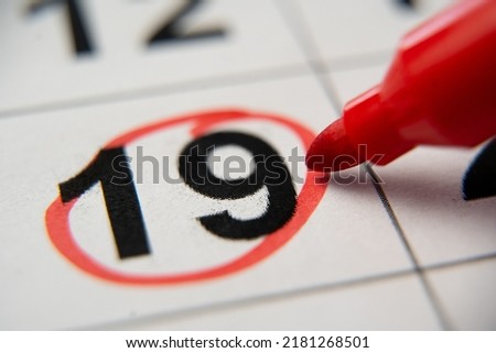 The calendar 19th day of the month is circled. A red marker circles the nineteenth day of the month from the paper calendar. A very important date in the calendar