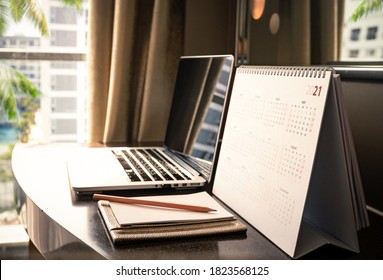 Calendar 2021 with computer notebook on desk 