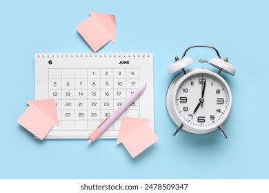 Calendar with alarm clock and office stationery on blue background - Powered by Shutterstock