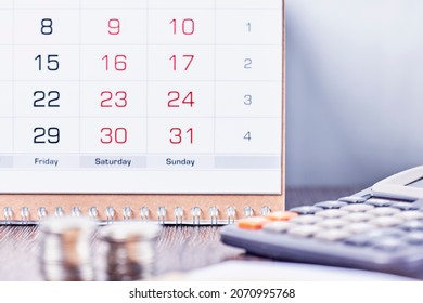 Kalender, Taschenrechner und Stack von Münzen im Büro. Terminkonzept. Kalender, Münzen und Taschenrechner auf dem Tisch. Konzepte der Unternehmens-, Finanz-, Steuer-, Buchhaltungs-, Lohn-, Lohn- und Gehaltsbuchhaltung
