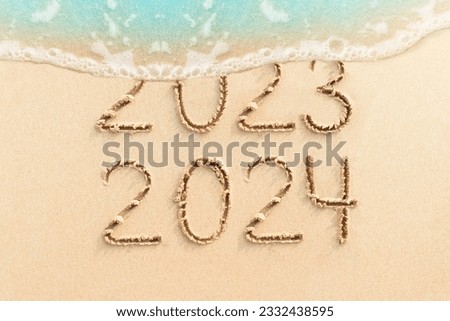 Calendar and New Year 2024 concept  photo. Handwritten numbers 2023 on the beach with soft ocean wave on background